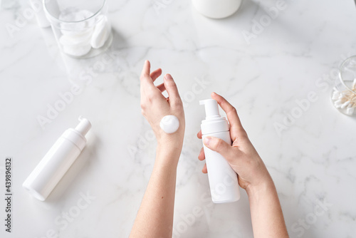 Female hands with cleansing foam bottle. photo