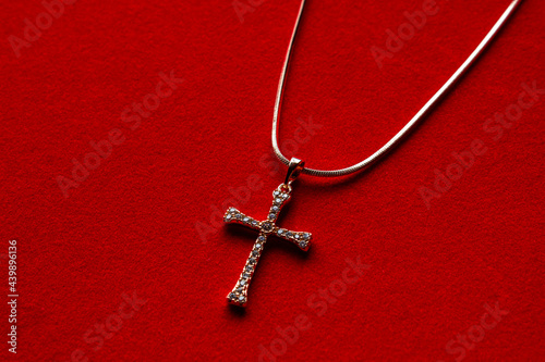 Crystal cross shaped pendant on gold chain isolated over white