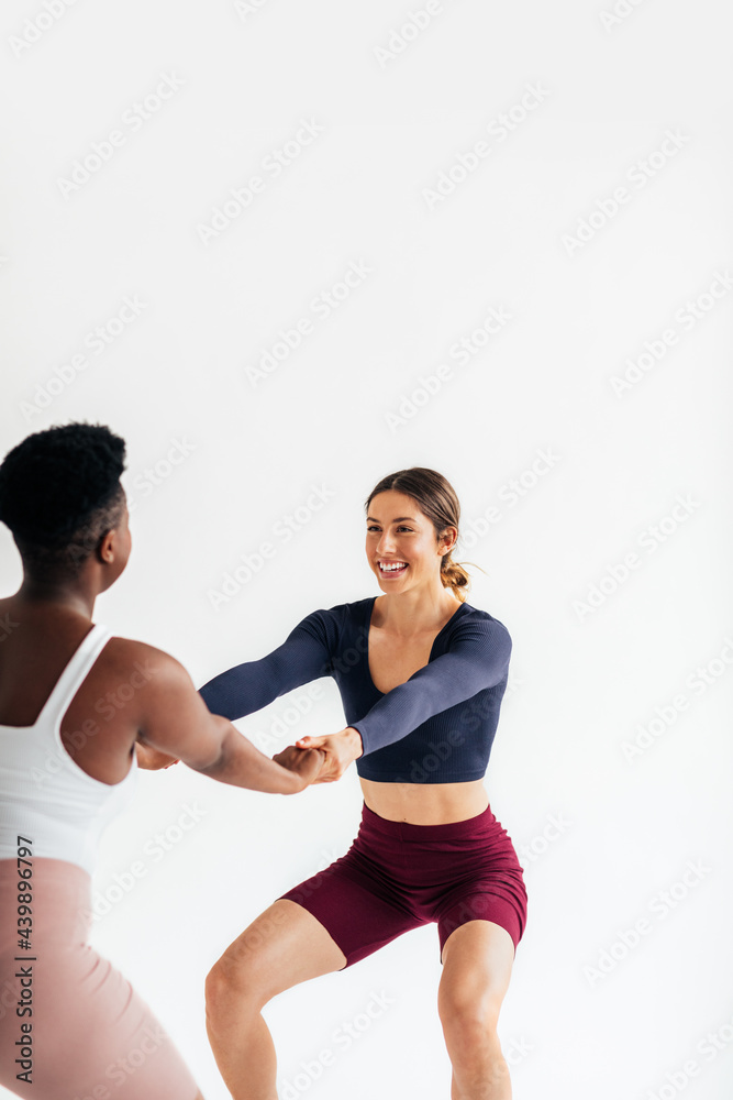 Two Sportswomen Exercising Together in Studio Two Sportswomen Exercising Together in Studio