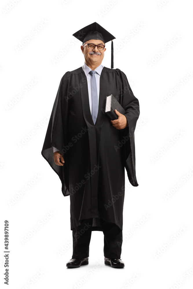 Full length portrait of a mature man in a graduation gown holding a book Full length portrait of a mature man in a graduation gown holding a book