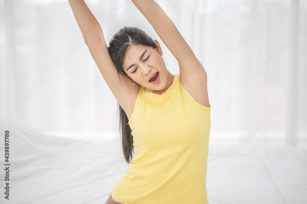 Young woman wake up in the morning and stretching on her bed Young woman wake up in the morning and stretching on her bed