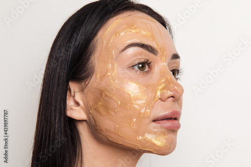 Woman with gold gel facial mask 