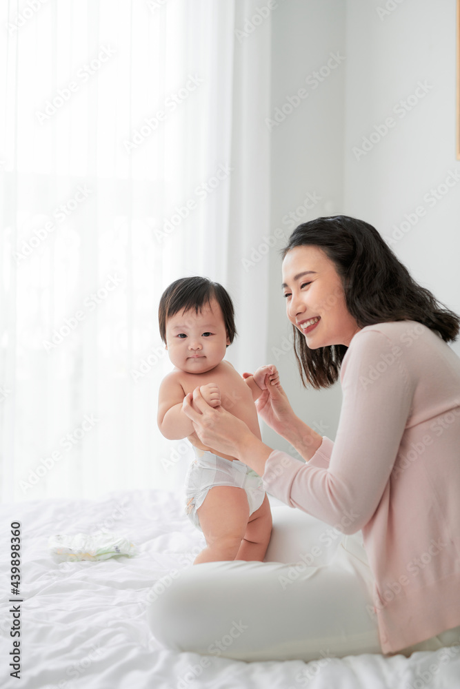 Mother helping seven month old baby learn to walk Mother helping seven month old baby learn to walk