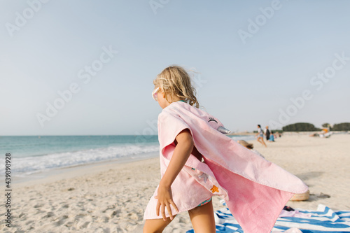 A little girl in pink towel on the beach photo