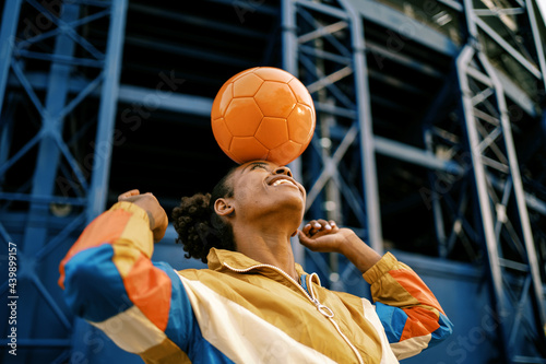 Female footballer with ball in city photo