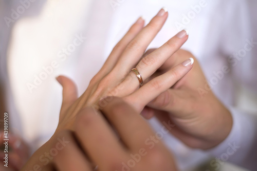 hands close-up, the groom puts a ring on the bride's finger