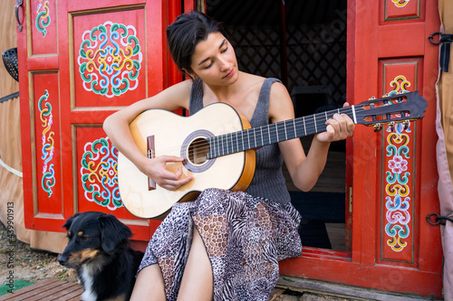 Woman Playing Guitar In A Yurt.  photo