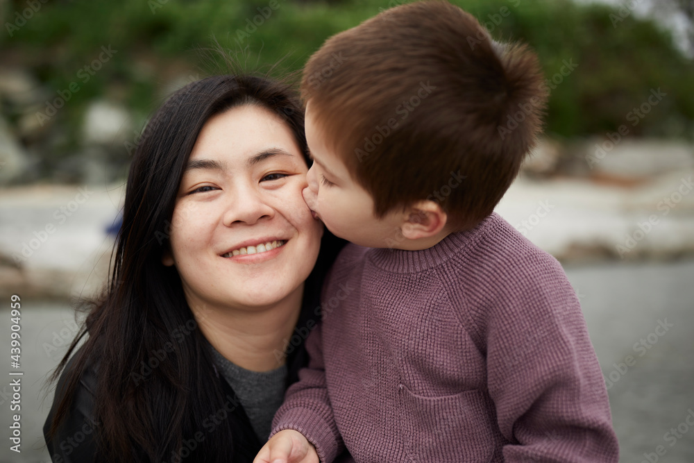 Young Mixed Race Boy Kisses His Chinese Mother On Her Cheek Young Mixed Race Boy Kisses His Chinese Mother On Her Cheek