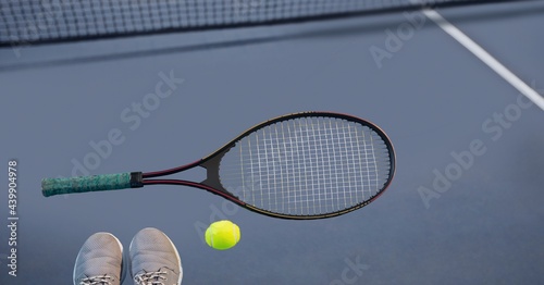 Composition of tennis ball, sports shoes and racket on tennis court