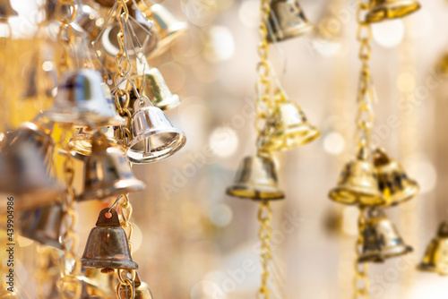 Selective focus golden bells hanging in the golden chain with blurry golden belle hanging in the golden chain.