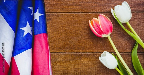 American flag and pink and white tulip flowers on wooden background