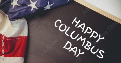 Happy columbus day text on wooden slate and american flag on white background