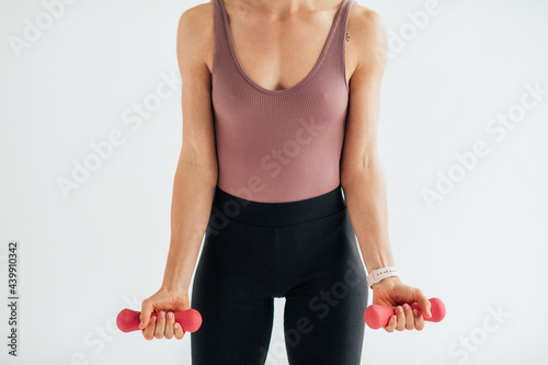 Sportswoman Exercises with Weights in Studio