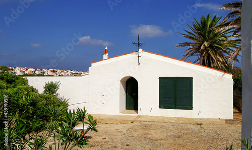 White house with green windows and blue sky in Baleares islands