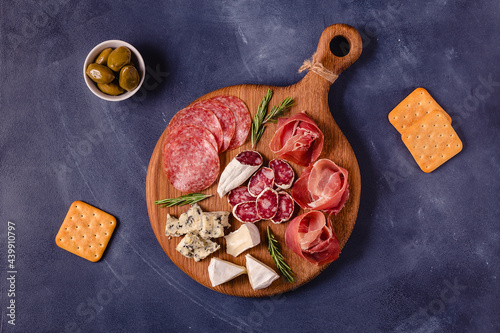 Serving board with meat and cheese snacks.