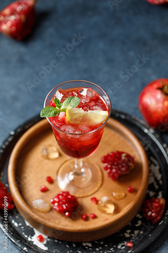 Pomegranate refreshing summer cocktail on dark background. Summer cocktail