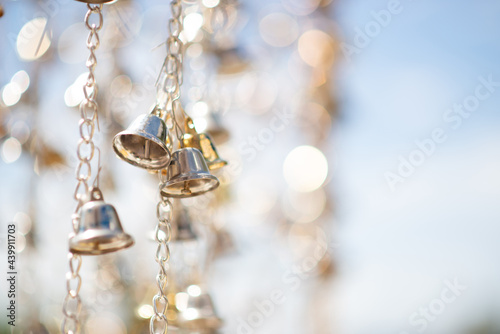 Selective focus golden bells hanging in the golden chain.