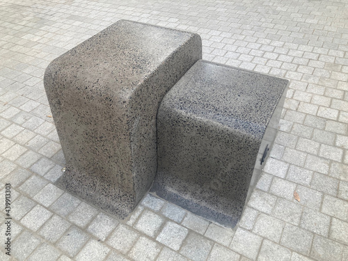 Abstract terrazzo precast concrete single seat and table. There is lighting in the side. Gauging from its proximity to the road I would say it also cleverly doubles as a bollard. Street furniture. photo