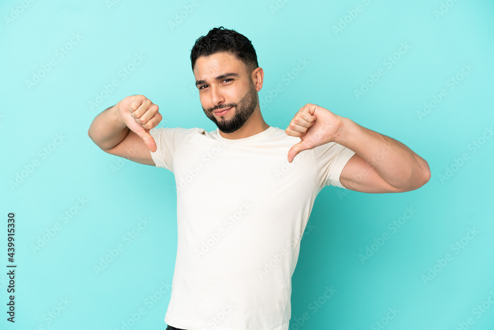 Young arab man isolated on blue background proud and self-satisfied Young arab man isolated on blue background proud and self-satisfied