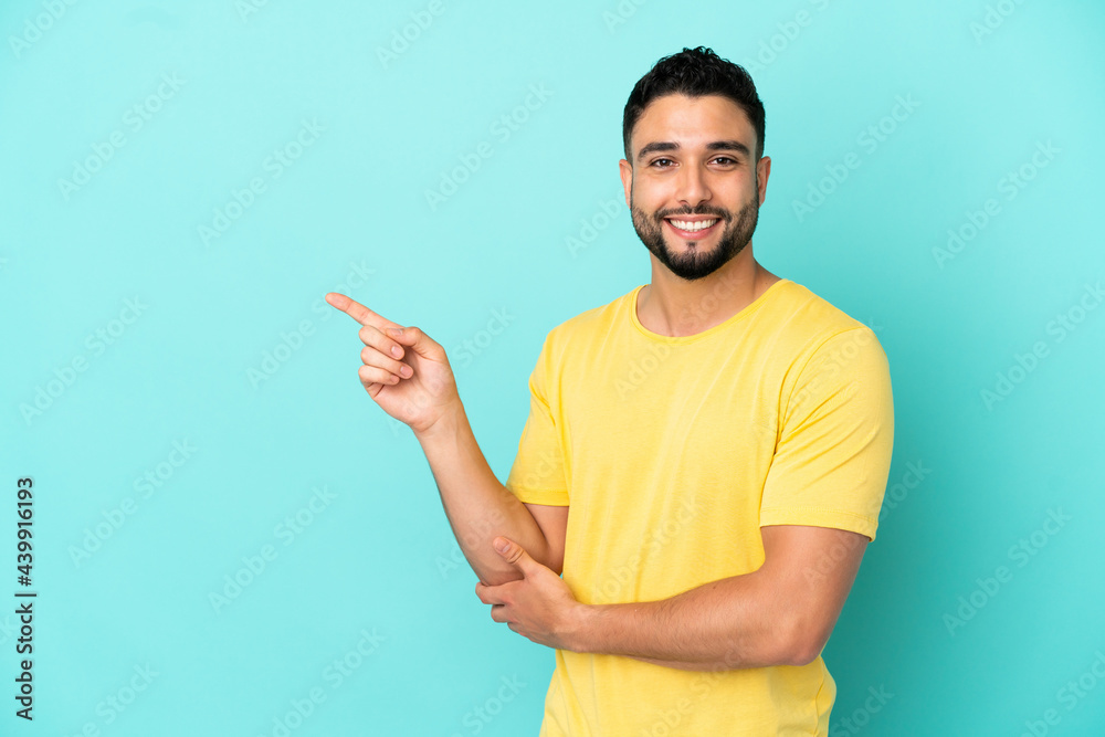 Young arab man isolated on blue background pointing finger to the side Young arab man isolated on blue background pointing finger to the side