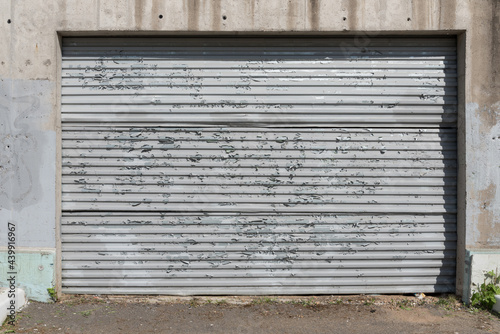 An old, peeling sheet of iron. Fence or garage door. The influence of atmospheric precipitation on the paintwork
