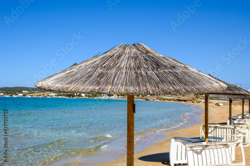 Fototapeta Naklejka Na Ścianę i Meble -  Straw umbrella at Xifara beach, a small and quiet beach located in Naoussa Bay on Paros island, Cyclades, Greece