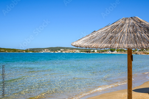Straw umbrella at Xifara beach  a small and quiet beach located in Naoussa Bay on Paros island  Cyclades  Greece