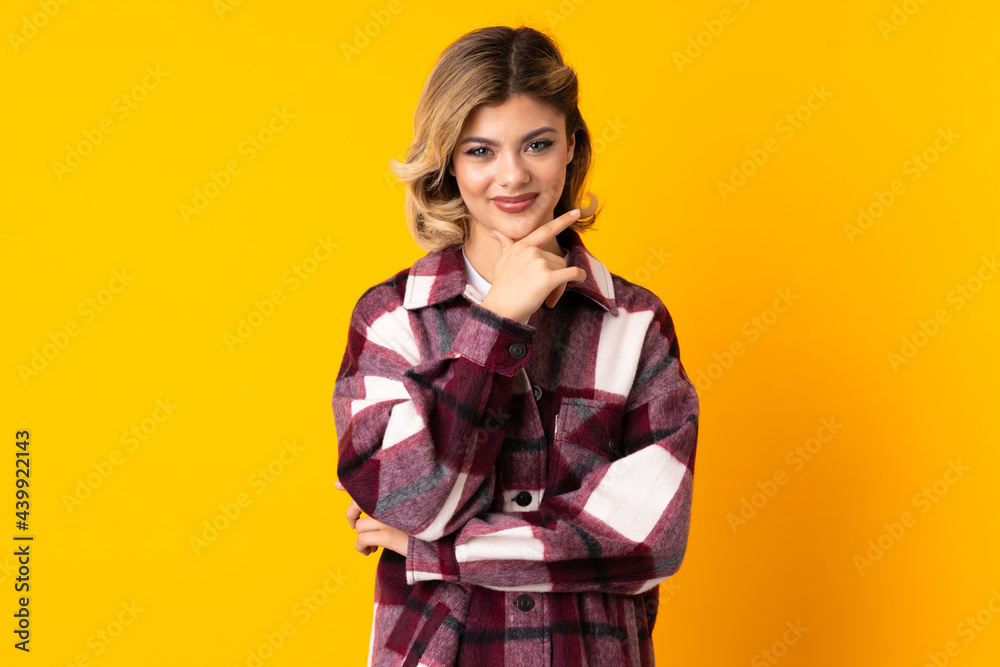 Young Russian woman isolated on yellow background thinking an idea while looking up Young Russian woman isolated on yellow background thinking an idea while looking up