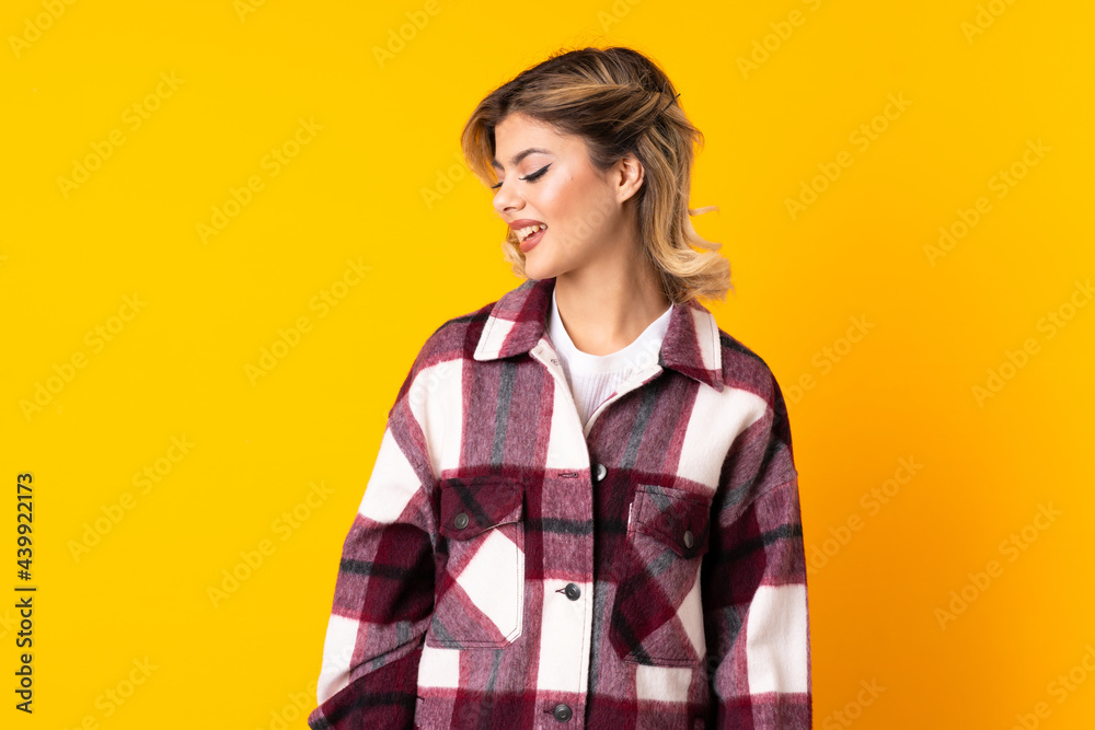 Young Russian woman isolated on yellow background looking to the side and smiling Young Russian woman isolated on yellow background looking to the side and smiling