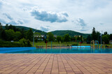 Swimming pool with a playground for children against the backdrop of the mountains