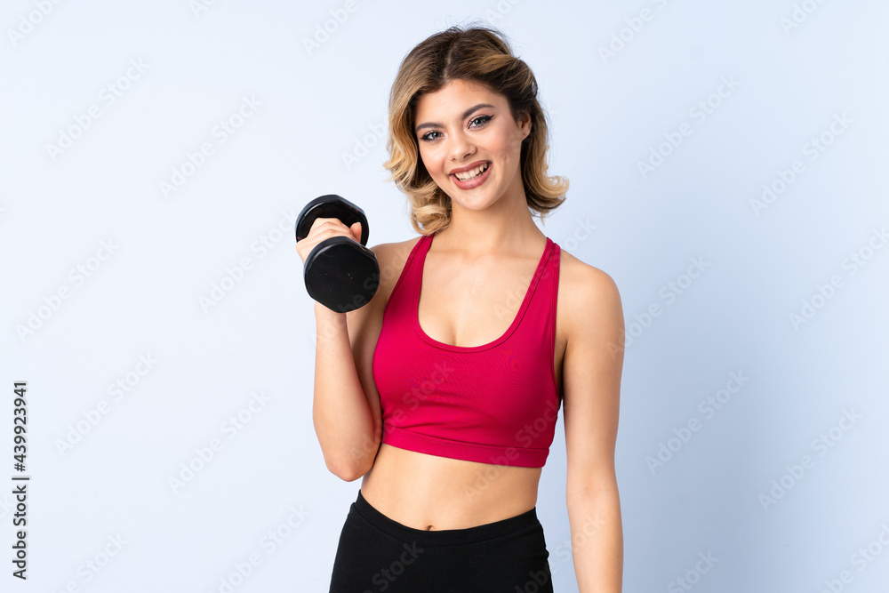 Teenager Russian girl making weightlifting isolated on blue background thinking an idea and looking side Teenager Russian girl making weightlifting isolated on blue background thinking an idea and looking side