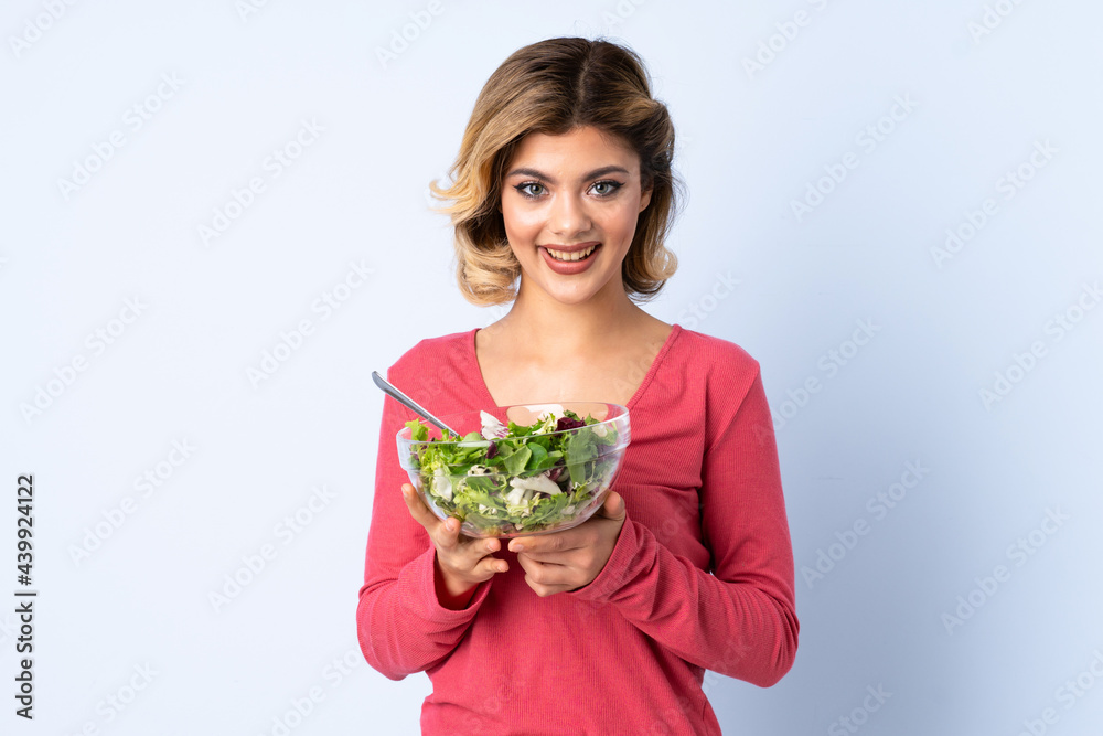 Teenager woman with salad isolated on blue background with surprise and shocked facial expression Teenager woman with salad isolated on blue background with surprise and shocked facial expression