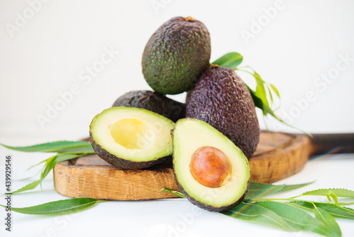 Mature ripe avocado haas with leaves on a white background, selective focus photo