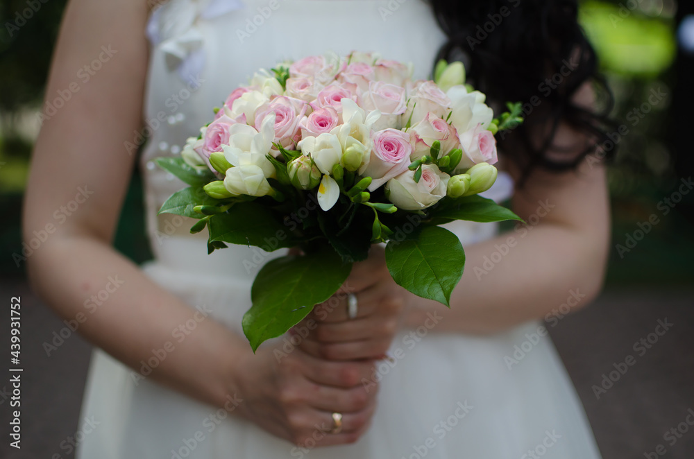 wedding bouquet with pink roses in the hands of the bride wedding bouquet with pink roses in the hands of the bride