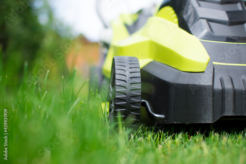 Green lawn mower, close up view on part of mower. Gardening concept.
