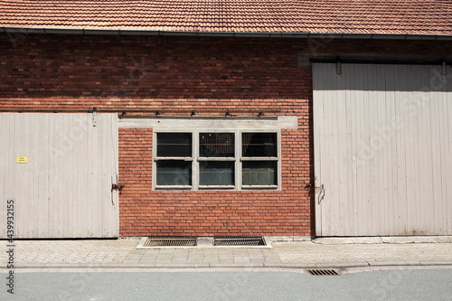 Fenster und große pastellfarbene Holztore in der Backsteinfassade einer alten Scheune bei Sonnenschein in der Provinz in Alverdissen im Exertal bei Barntrup im Kreis Lippe in Ostwestfalen-Lippe photo