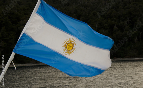 Argentine flag waving on boat, with lake and mountains in the background photo