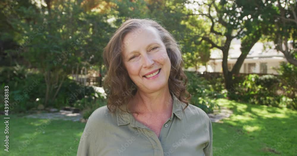 Portrait of happy senior caucasian woman standing in garden smiling Portrait of happy senior caucasian woman standing in garden smiling
