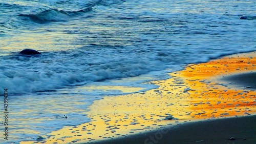 Colorful sunset reflecting in an wet sand beach