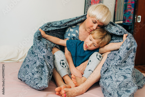Mom and her 5 years old son playing in bed photo