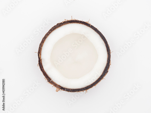 Half a coconut with fresh flesh and peel isolated on a white background.