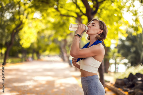 Sports woman drinking water outdoor. Fitness and healthcare concept