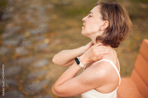 Woman with neck pain outdoor. Healthcare and medicine concept