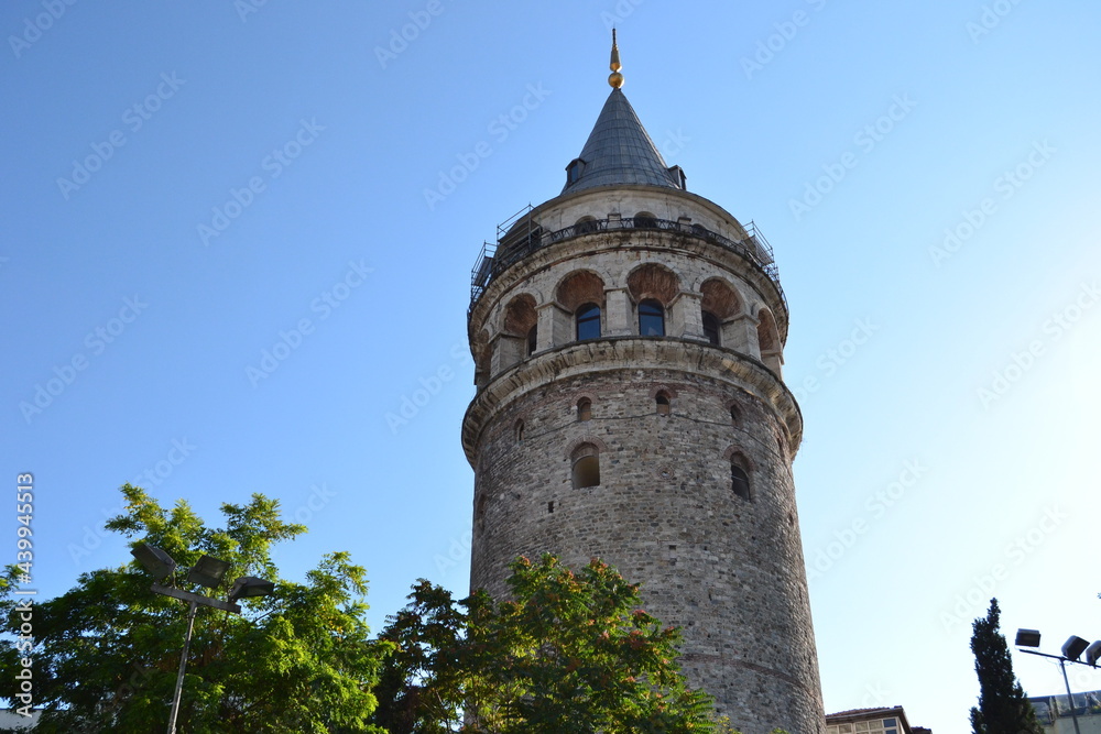 Galata tower in Istanbul under clear blue sky and sunlight.