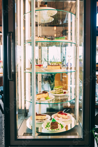 Fotografie Glass showcase refrigerator with desserts inside illuminated by lamps