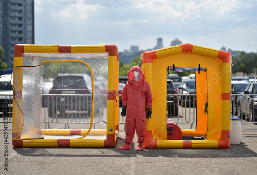 manikin in biohazard suit near person decontamination tents photo