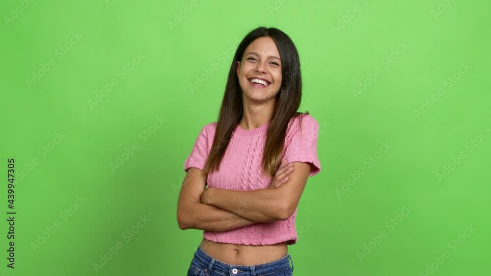 Young woman keeping the arms crossed while smiling over isolated background. Green screen chroma key Young woman keeping the arms crossed while smiling over isolated background. Green screen chroma key