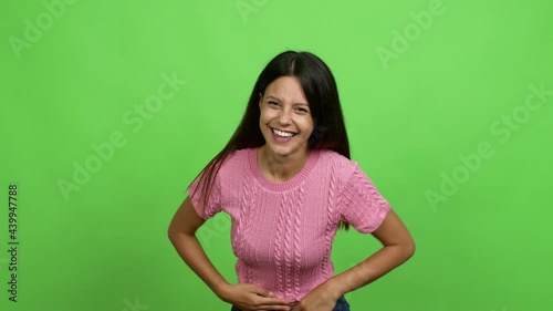 Young woman smiling a lot while covering mouth over isolated background. Green screen chroma key