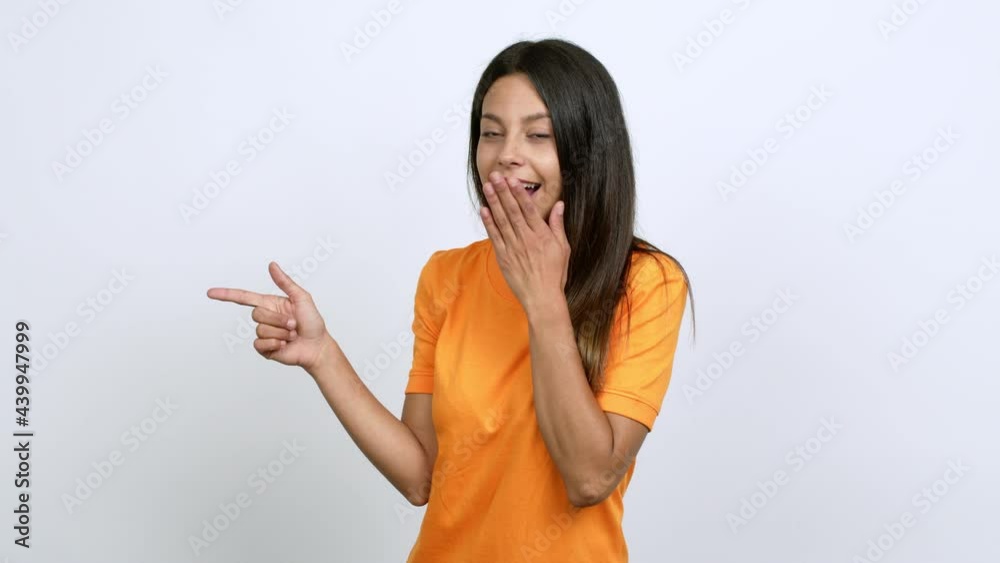 Young woman pointing to the side and presenting a product while smiling over isolated background Young woman pointing to the side and presenting a product while smiling over isolated background