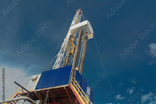 Drilling rig for drilling wells for oil and gas. General detailed view. View from the side from bottom to top.  Drill tower on the base and drill pipes for lowering into the well photo